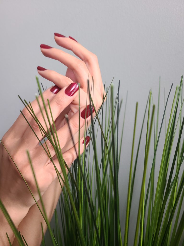 Image of hands held up against grass